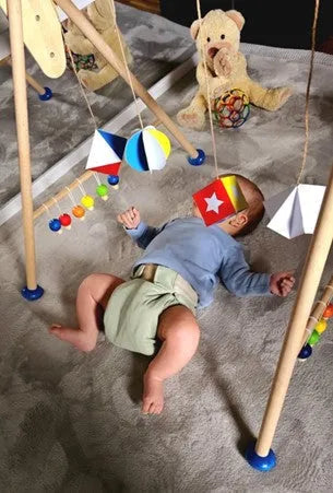 Baby unter Spielebogen