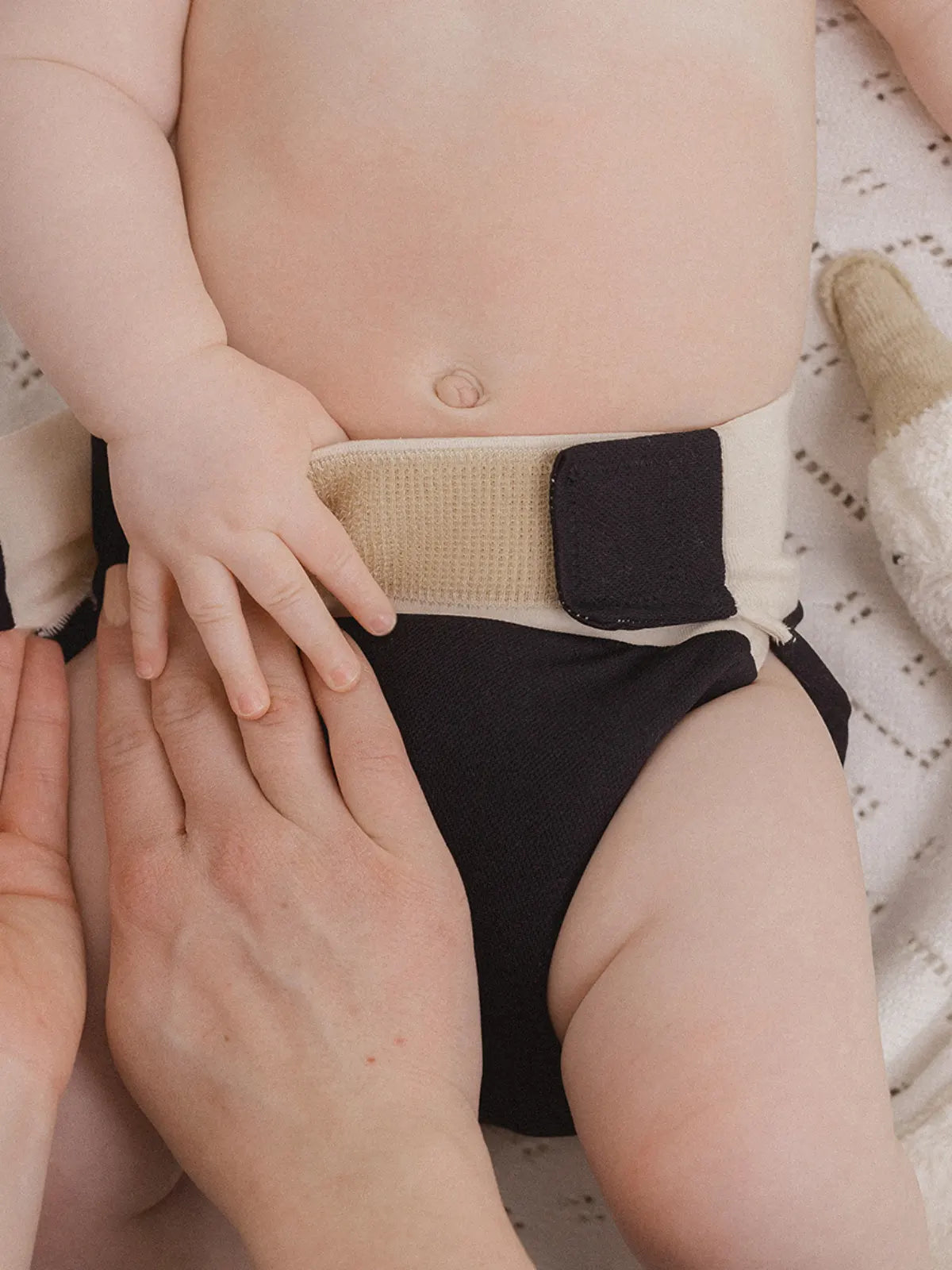 Baby wird mit kniti gewickelt